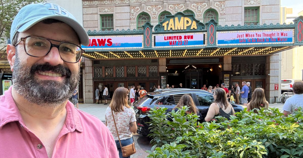 Man standing in front of Jaws movie marquee sign.